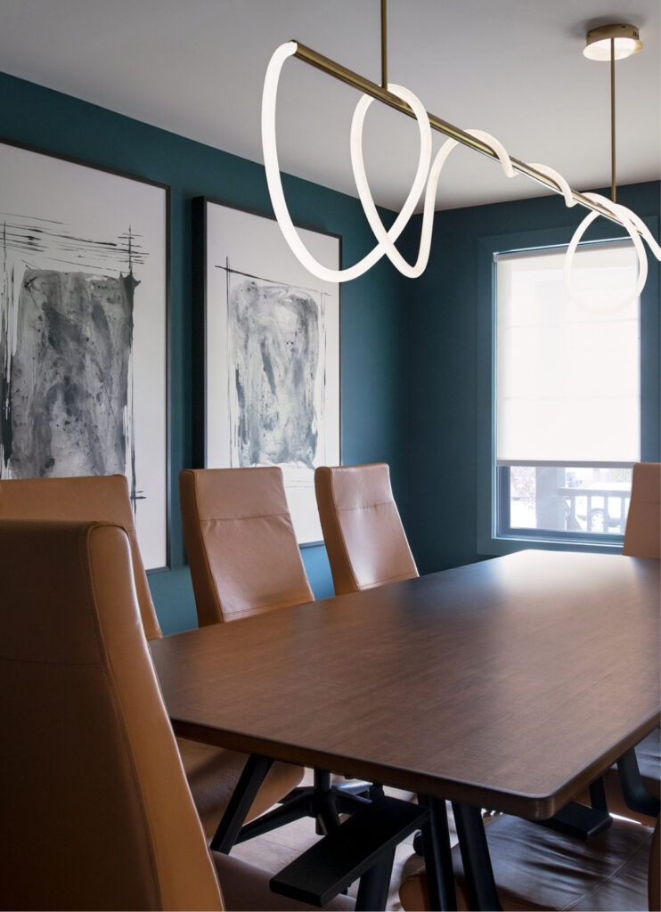 Chatham office interior view of conference room with sleek table and leather backed chairs, contemporary paintings and light fixture.